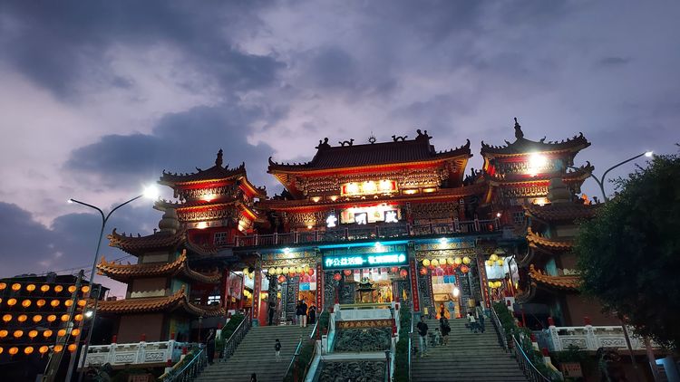 Ein buddhistischer Tempel mit breiter Treppe und heller Beleuchtung. 